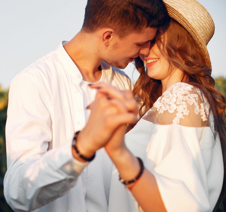 Couple kissing in field of sunflowers